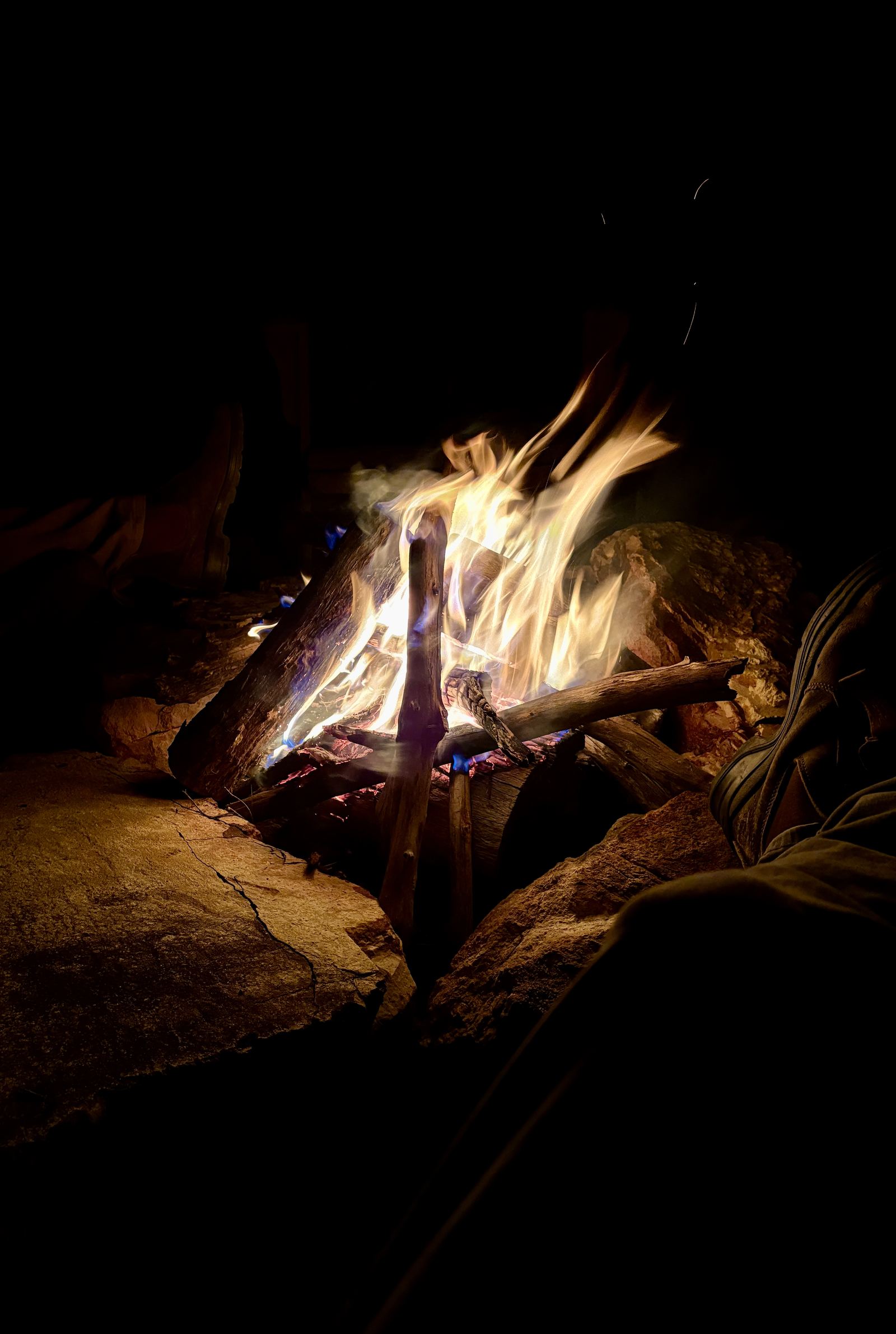 Bare feet warming on stone in front of an open fire.