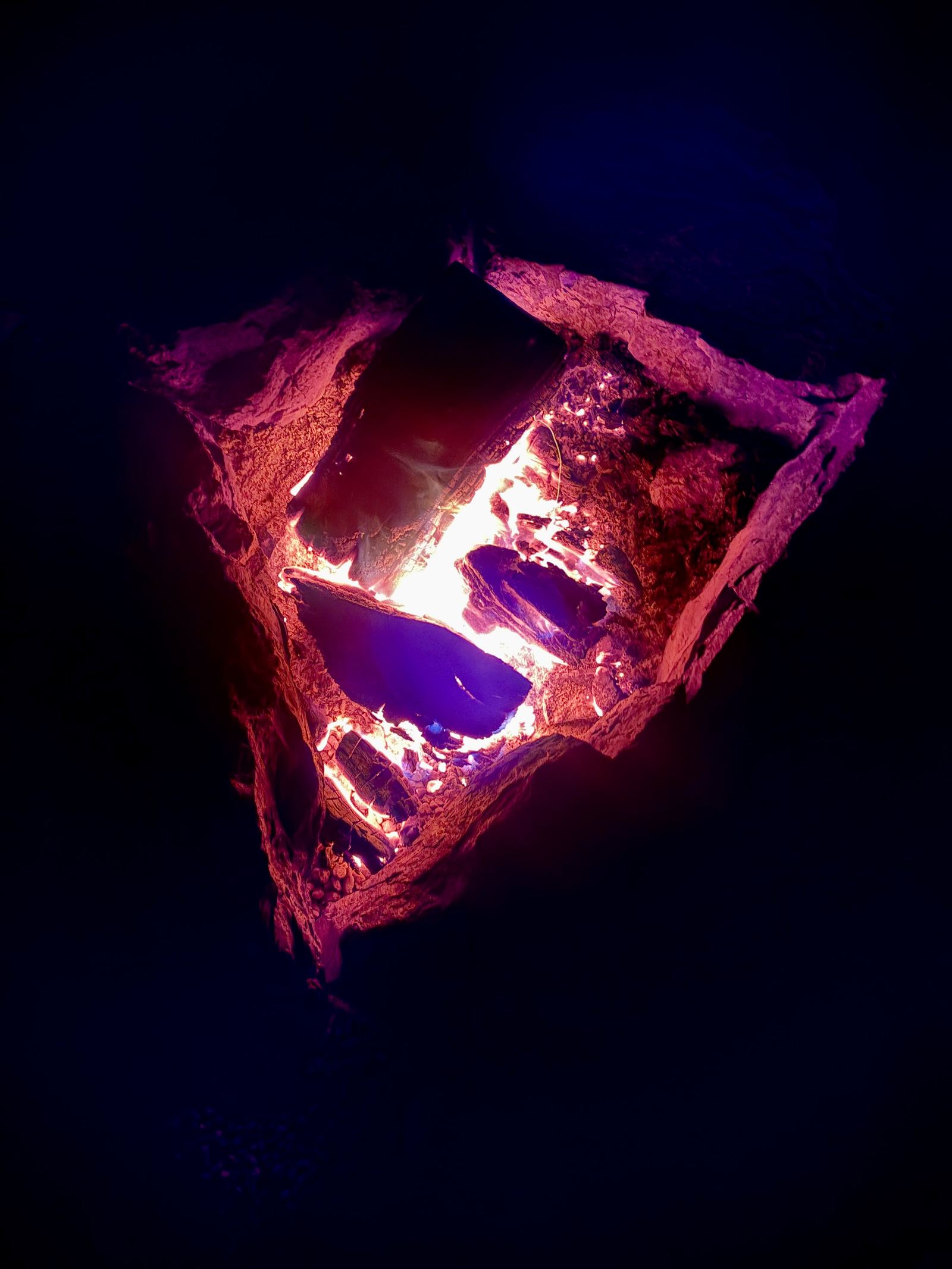 Glowing red and purple coals, close.